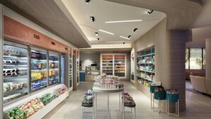 L'intérieur d'une épicerie moderne, avec des rayons réfrigérés, des étagères remplies d'en-cas et une table centrale servant de présentoir.