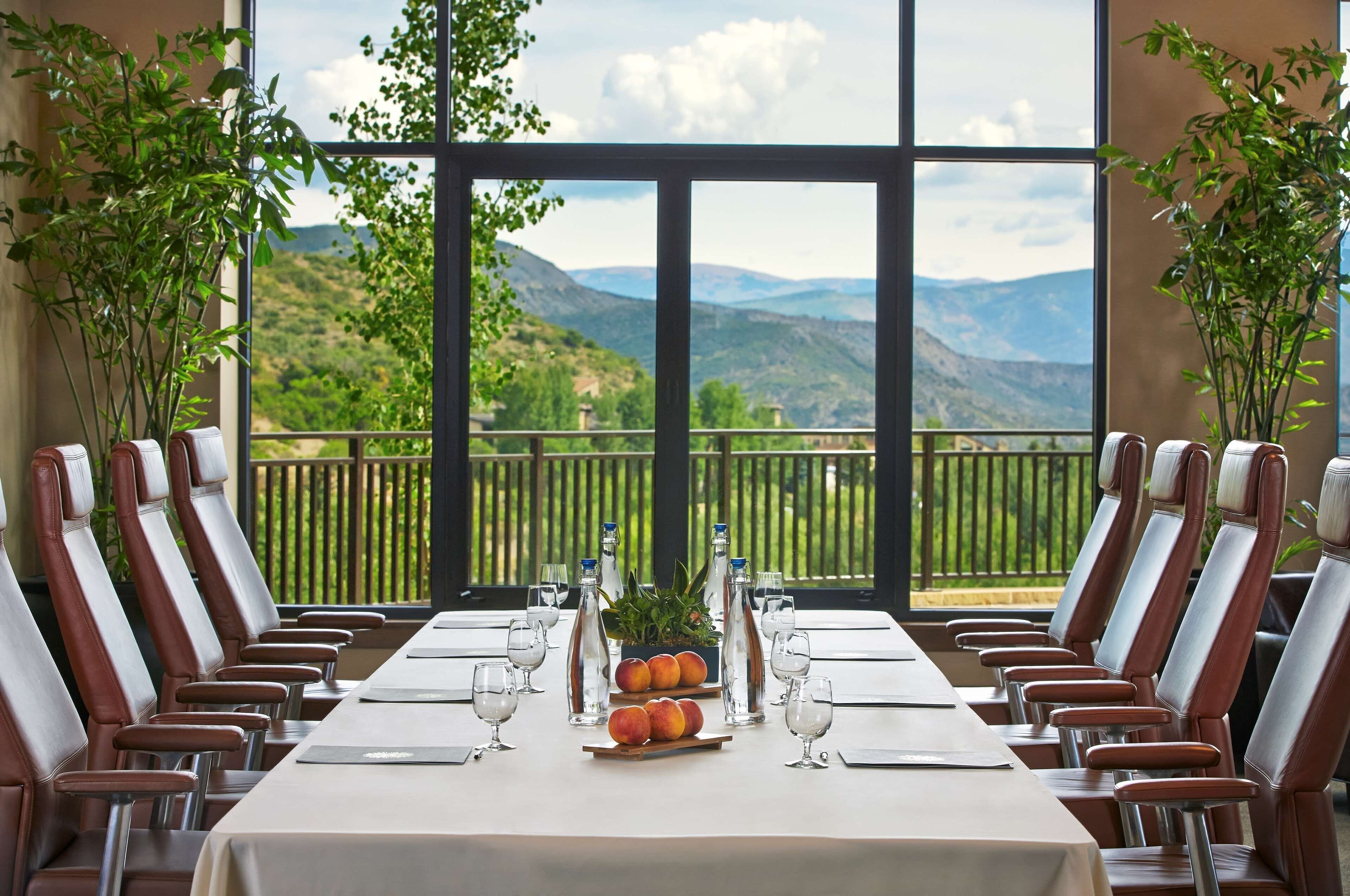 Mesa de jantar posta para dez pessoas, com vista para as montanhas.