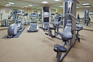 A gym with various exercise equipment including treadmills, elliptical machines, and weight machines.