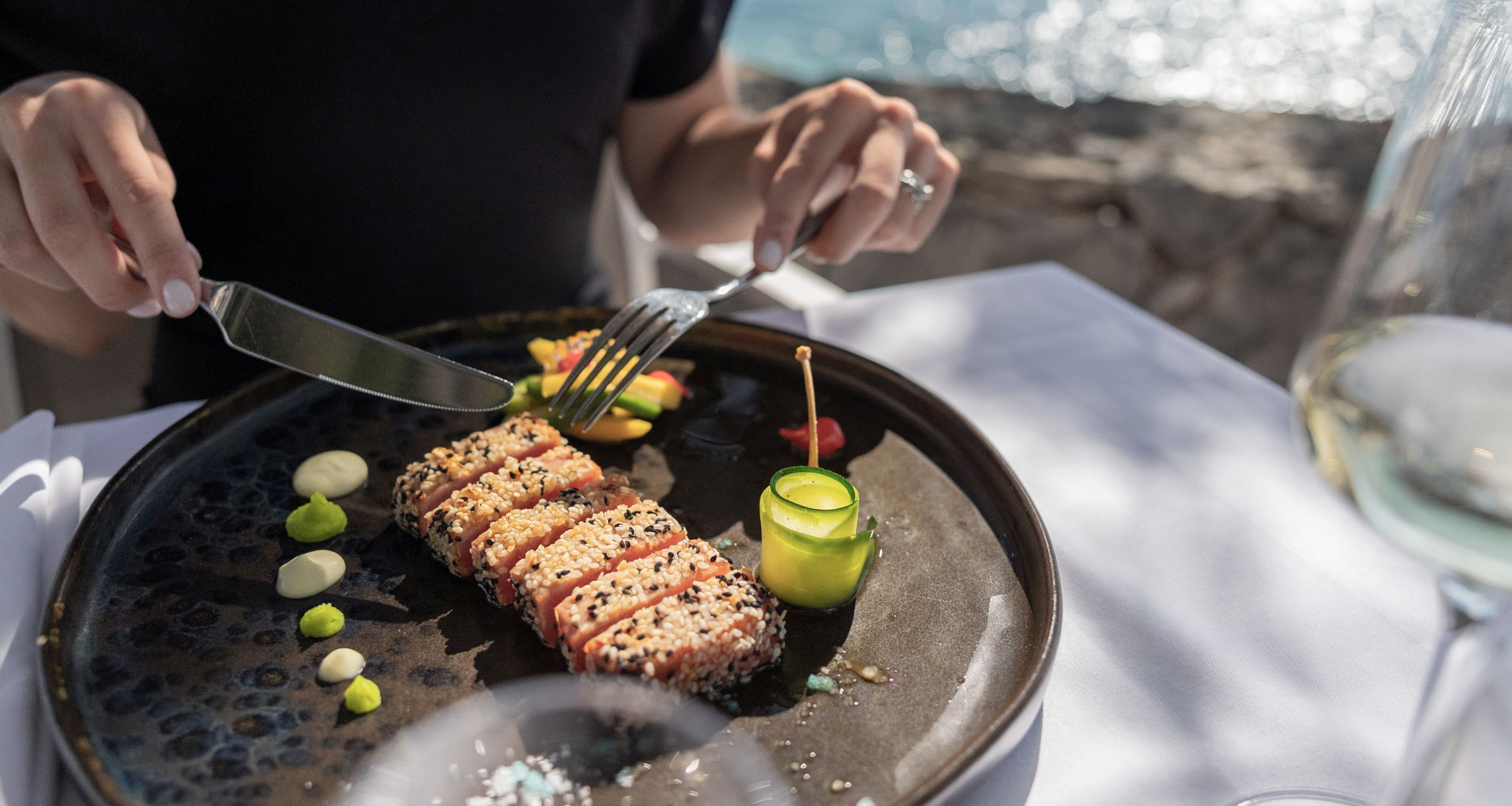 Una persona serve un piatto con una forchetta e un coltello.