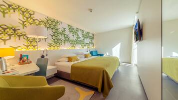 Una camera d'hotel moderna con un letto, comodino, lampada, sedia e una decorazione a parete.