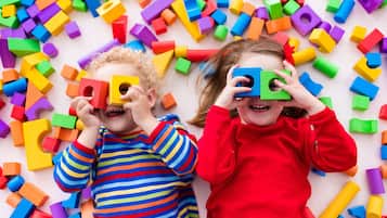 Zwei Kinder spielen mit bunten Bauklötzen.
