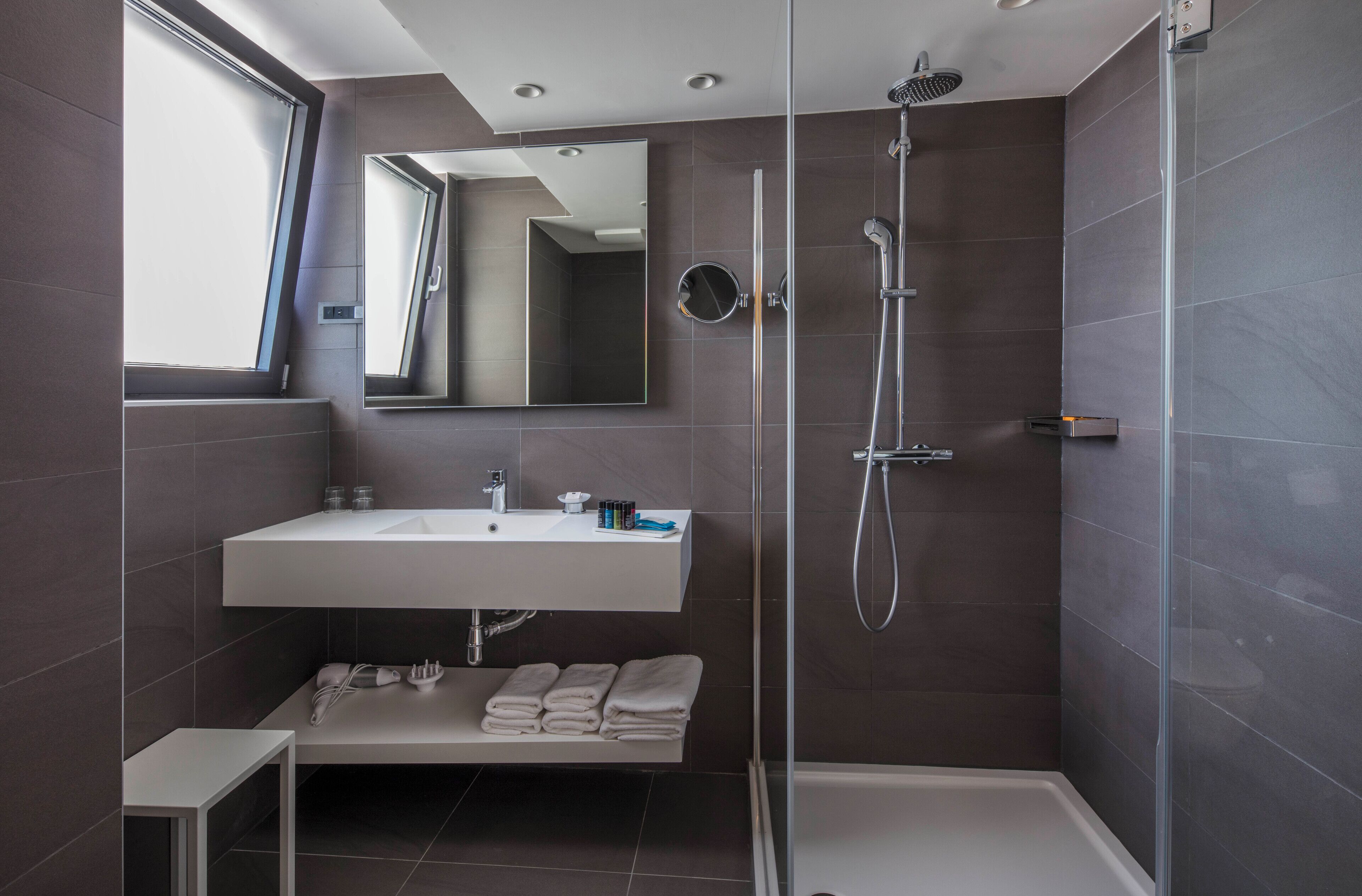 Ein modernes Badezimmer mit Dusche, Waschbecken und Spiegel.
