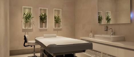 A modern bathroom with a bed, a sink, and three wall-mounted planters with flowers.