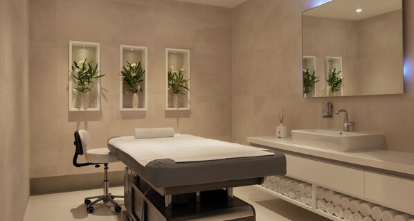 A modern bathroom with a bed, a sink, and three wall-mounted planters with flowers. - Bluesun Hotel Berulia (Brela)