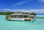 A luxurious overwater bungalow with a private pool, a slide, and a deck extending into the turquoise sea.