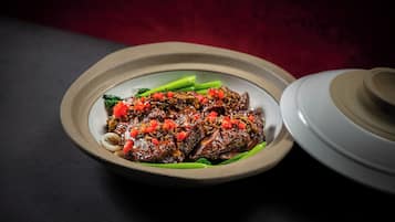 A plate of food with a bowl and a pot in the background.