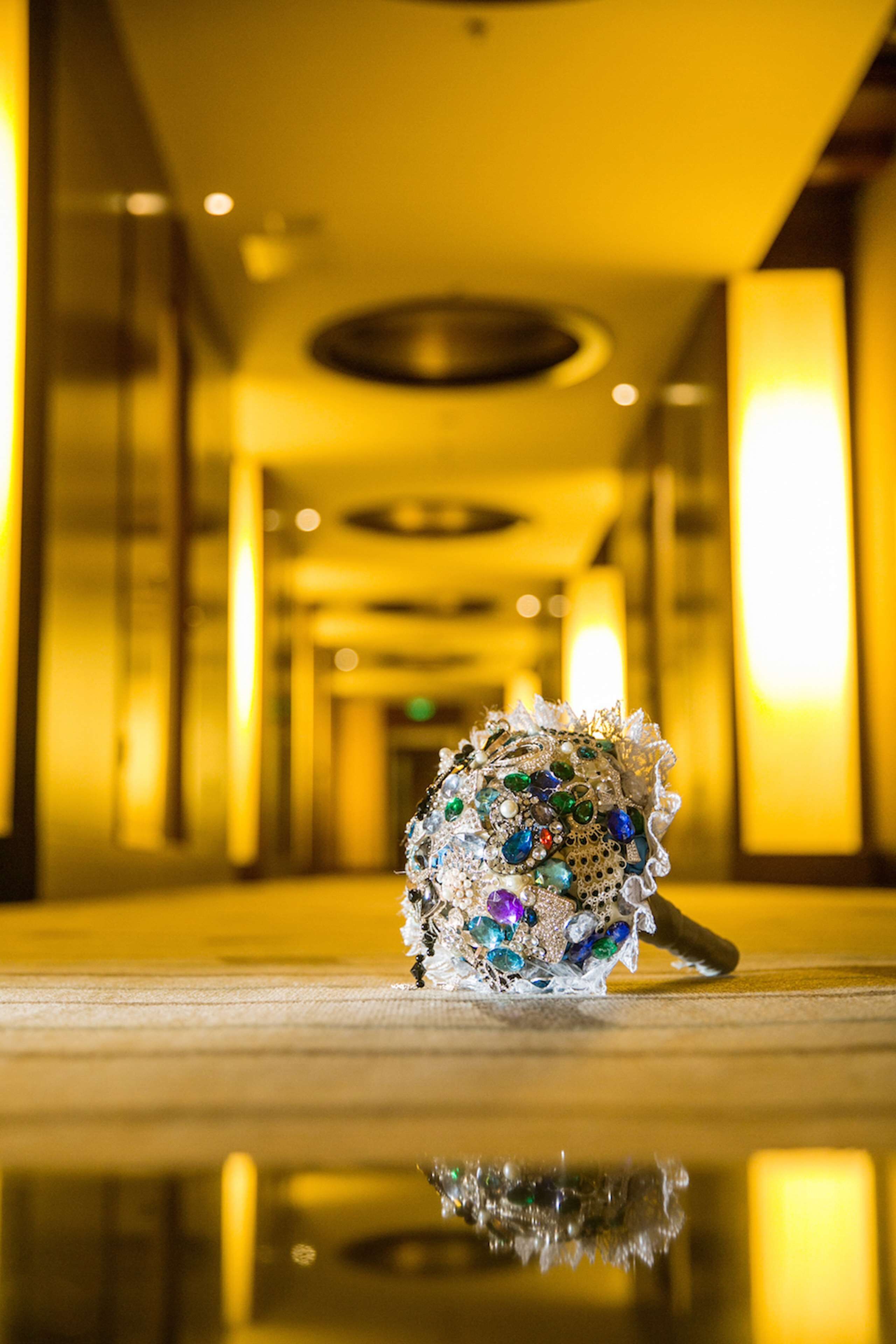 A decorative item with jewels on a reflective surface in a well-lit corridor.