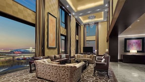 A spacious living area with a large sofa set, a flat-screen TV, and a chandelier.