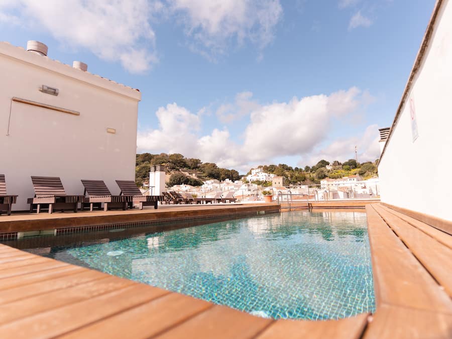 Een buitenzwembad, ligstoelen bij het zwembad