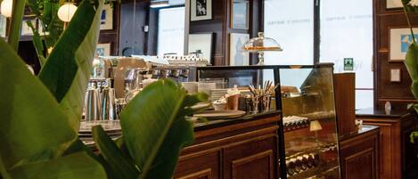 A restaurant interior with wooden cabinets, a glass display case, and hanging plants.