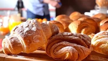 Variedad de pasteles a la vista, incluyendo croissants y otras delicias horneadas.