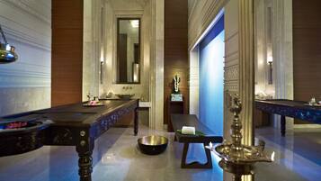 Un baño lujoso con un lavabo de mármol, un espejo grande y una fuente decorativa.