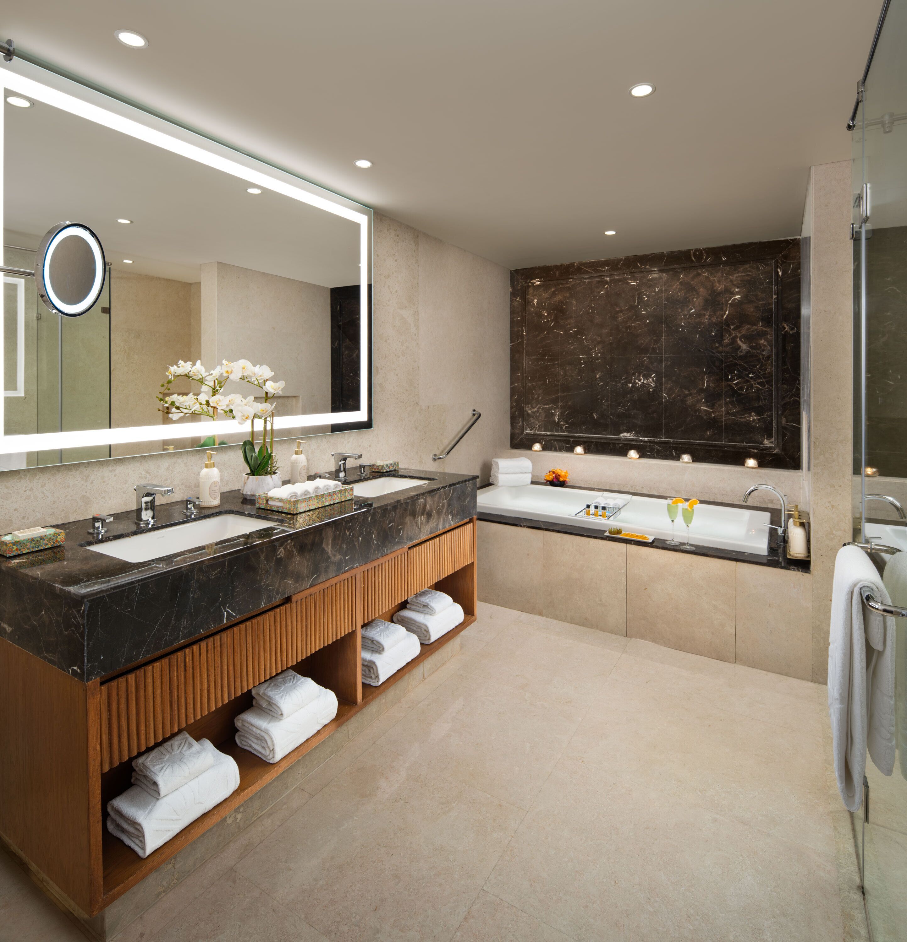 A modern bathroom with two sinks, a large mirror, and a marble backsplash.