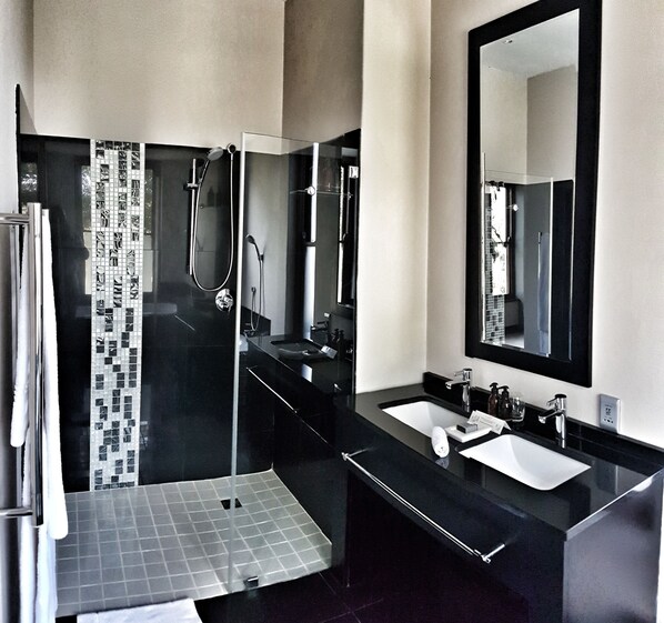 A modern bathroom with a glass shower enclosure, a large mirror, and two sinks. - Nova Constantia Boutique Residence (Cape Town)