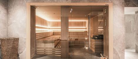Un spa moderno con un mostrador de recepción de madera, un panel de vidrio y una pared de piedra.
