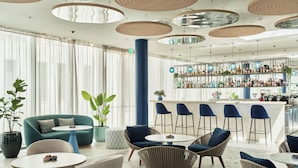 A modern bar area with seating, a bar counter, and a variety of bottles. - Falkensteiner Family Hotel Diadora (Zadar)