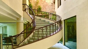 Un escalier en colimaçon avec une balustrade en verre menant à un deuxième étage.