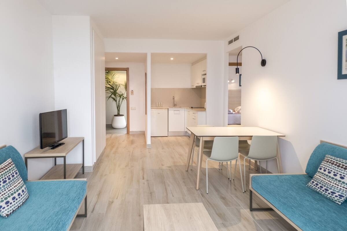 Um apartamento moderno com sala de estar, espaço para refeições e cozinha.