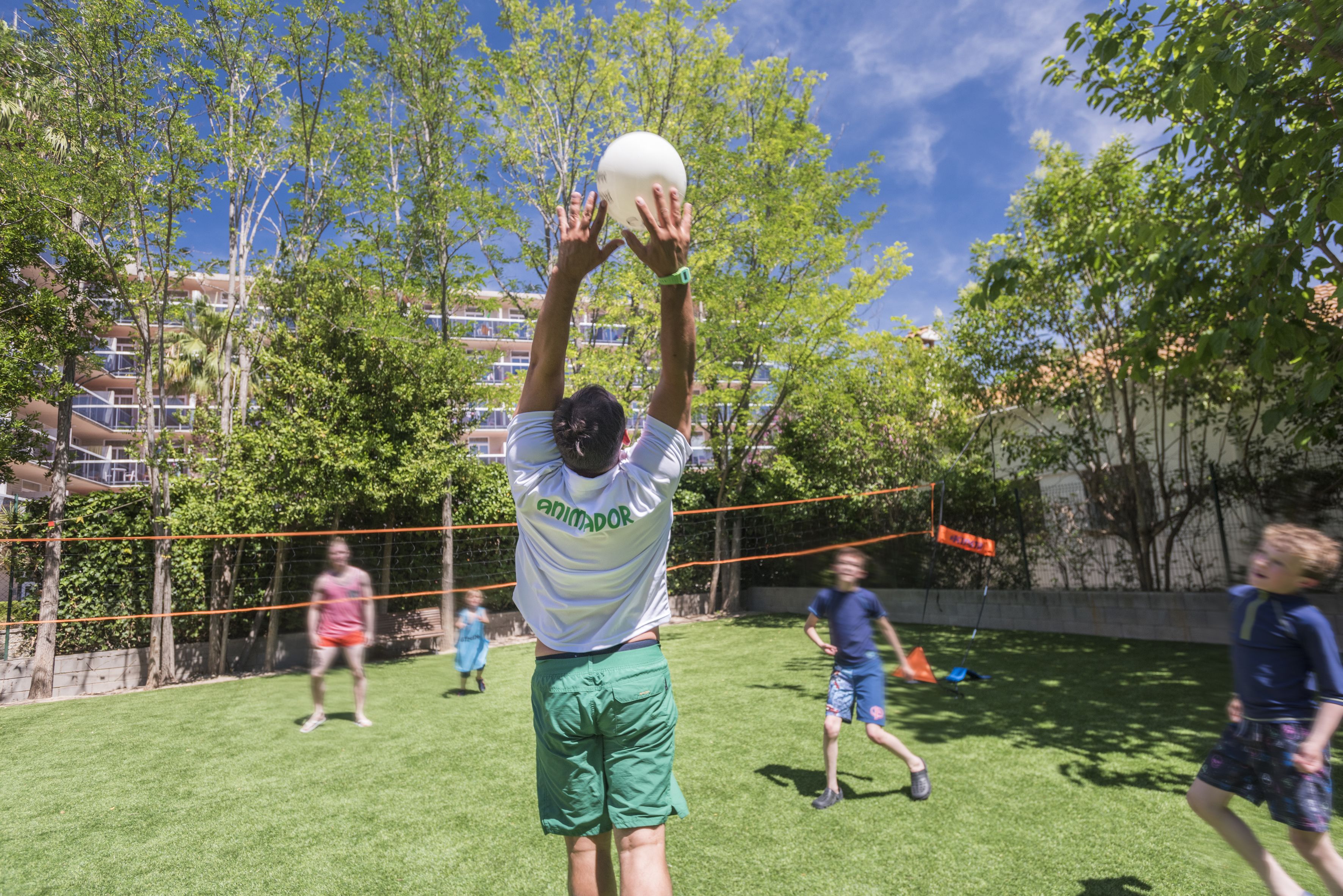 A person playing volleyball in an outdoor setting with a net.