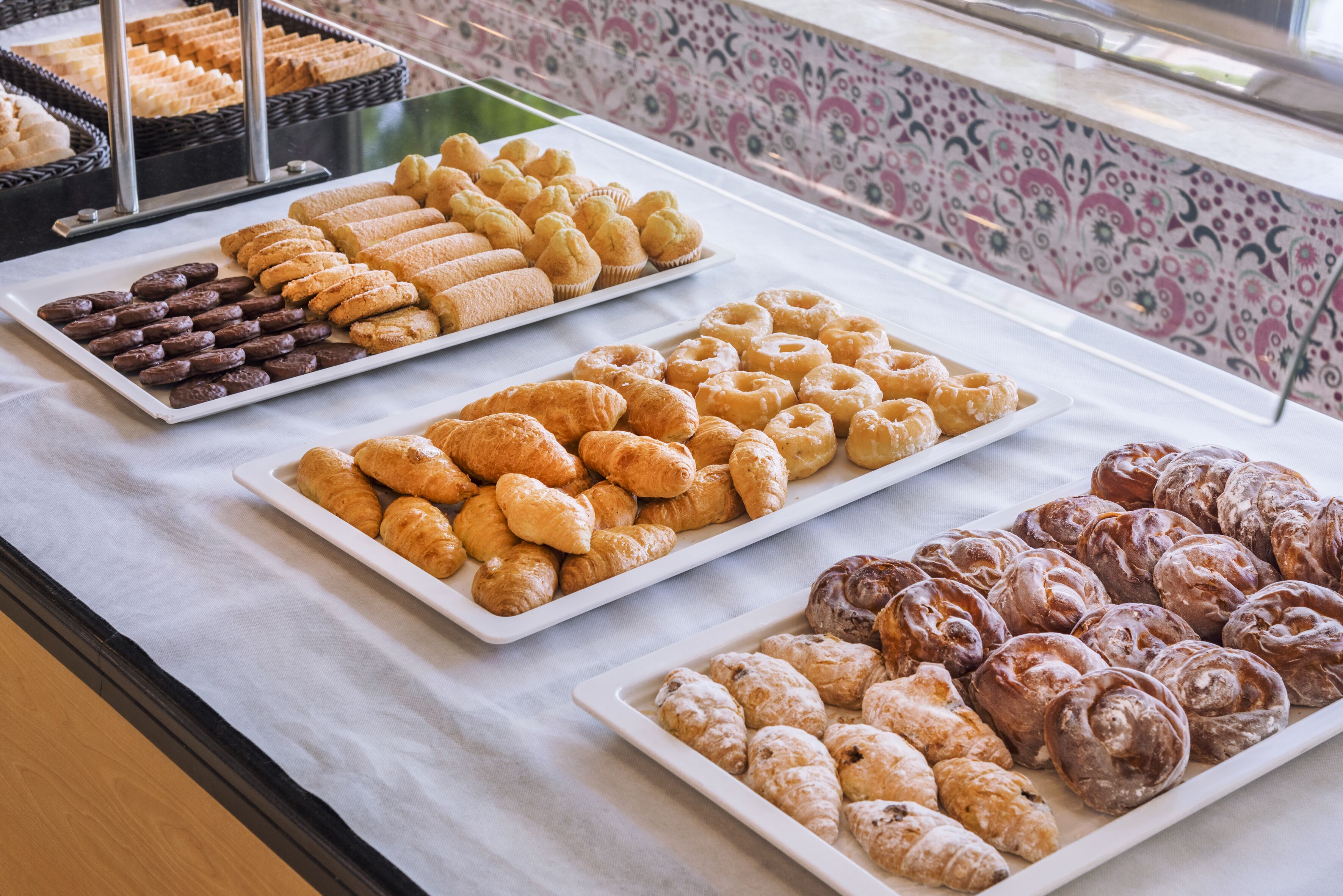 A buffet table with various pastries and baked goods.