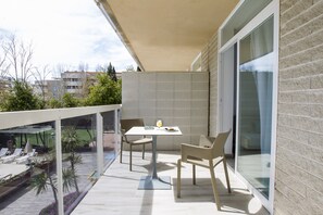 A balcony with a table and chairs, a glass door, and a view of the surrounding area. - Aparthotel CYE Holiday Centre (Salou)