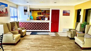 Ein Wohnzimmer mit roter Tür, beigen Sofas und einem Teppich mit Fischgrätmuster.