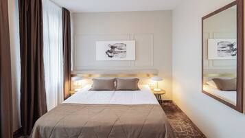 Habitación de hotel con una cama grande, una lámpara de noche, una obra de arte en la pared y un espejo.