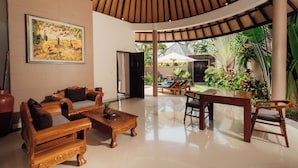 A spacious indoor area with a wooden ceiling, a sofa set, a coffee table, and a dining table. - The Bidadari Villas & Spa Umalas, between Seminyak and Canggu (Kerobokan)