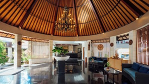 A spacious lobby with a high ceiling, a central chandelier, a reception desk, and a seating area with a sofa and a small table. - The Bidadari Villas & Spa Umalas, between Seminyak and Canggu (Kerobokan)