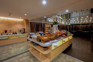 A breakfast buffet with various food items and a decorative orchid plant.