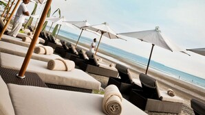 A beachside lounge area with sunbeds and umbrellas. - THE HAVEN Bali Seminyak (Seminyak)