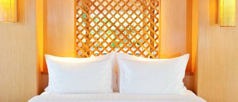 A hotel room with a large bed, a wooden headboard, and a decorative lattice wall.