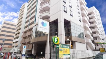 Welcome to the SkyHeart Hotel, featuring a modern entrance with a prominent sign and convenient parking options.