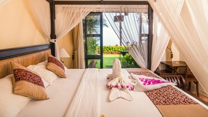 Une chambre d’hôtel avec un lit, une table et une vue sur un jardin.