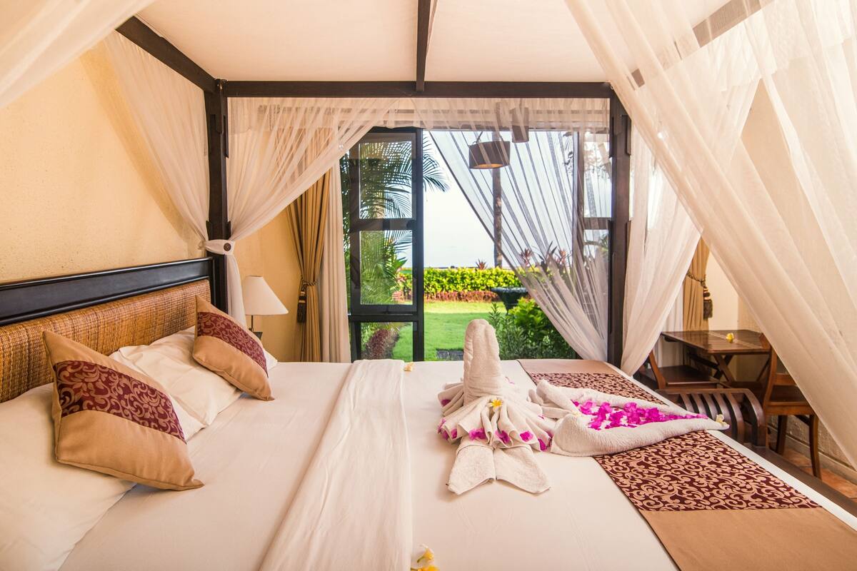 Una habitación de hotel con una cama, una mesa y vistas a un jardín.