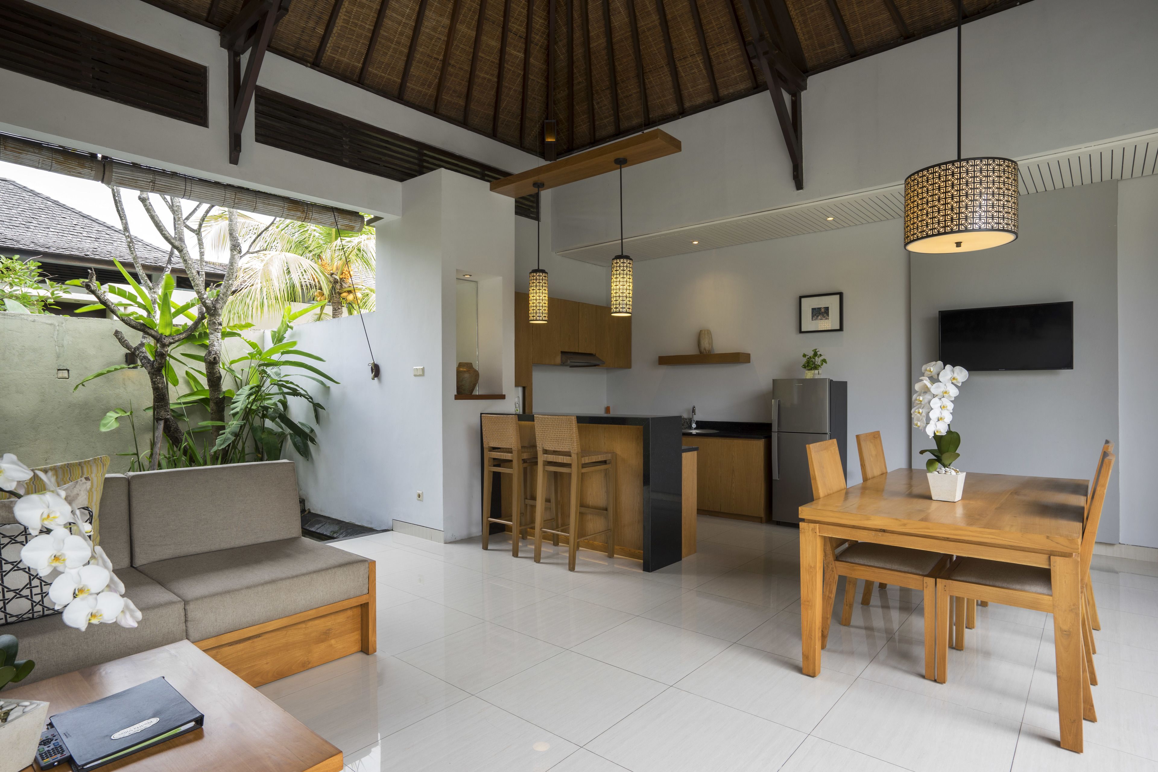 Una cocina moderna con una isla central, mesa de comedor de madera y taburetes de bar.