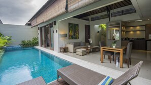 Une maison moderne dotée d’une piscine, d’un espace extérieur aménagé et d’un coin cuisine.