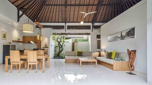 Un salon moderne avec un coin repas, un ventilateur de plafond et une vue sur un jardin.