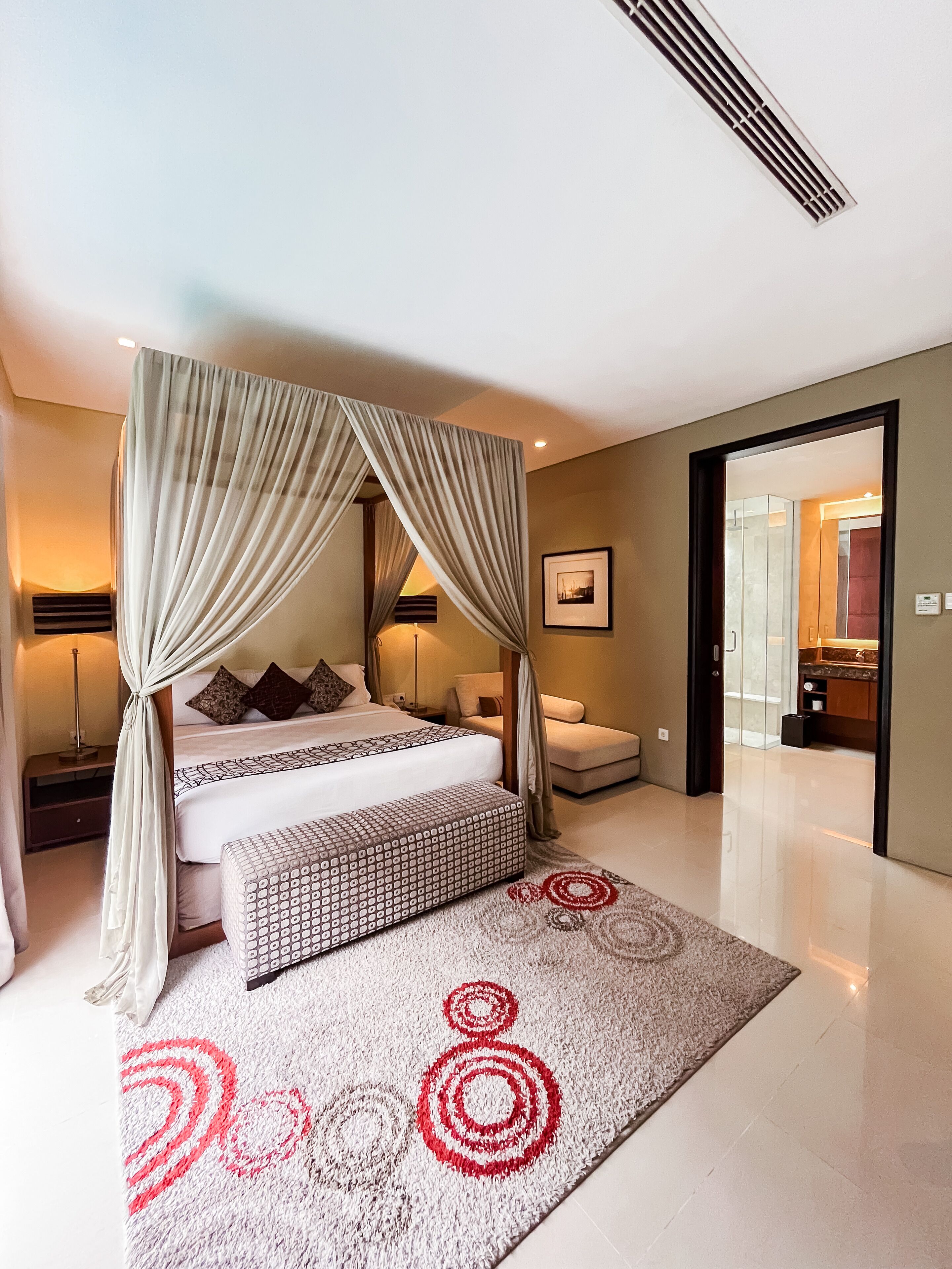 Une chambre d’hôtel moderne dotée d’un grand lit, d’un coin salon et offrant une vue sur la salle de bain.
