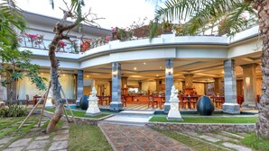 A hotel with a central courtyard, outdoor seating area, and a reception desk. - Puri Saron Seminyak (Seminyak)