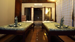 A room with two beds, a shower area, and a window with curtains. - Puri Saron Seminyak (Seminyak)