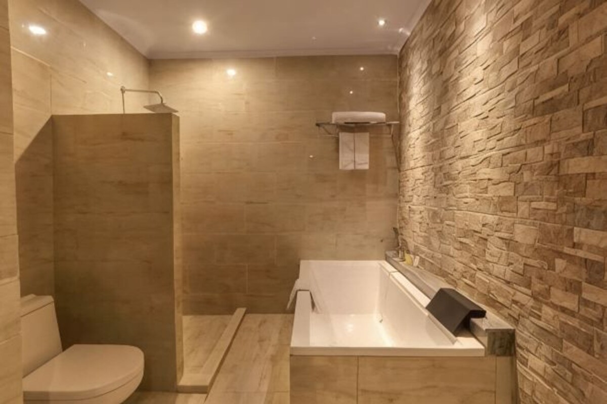A modern bathroom with a walk-in shower, a toilet, and a freestanding bathtub.