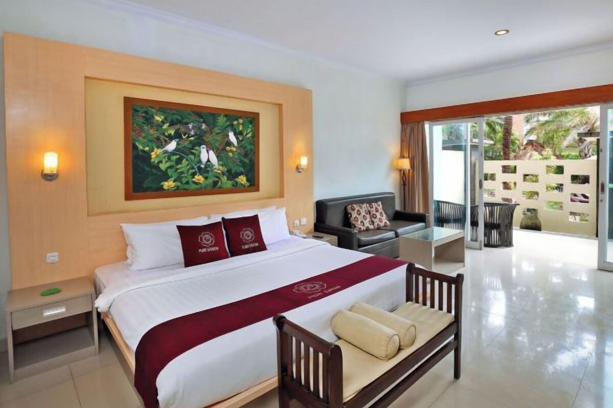 Habitación de hotel con una cama grande, un escritorio, una silla y vistas al exterior.