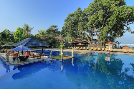 Una piscina al aire libre, sombrillas, sillones reclinables de piscina