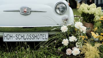 Un coche Fiat clásico con una matrícula que dice 'HDH-SCHLOSSHOTEL'.