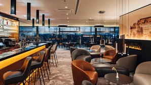 Un área de bar moderna con asientos y chimenea.
