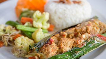 Une assiette de nourriture composée de riz, de légumes et d’un plat de viande.