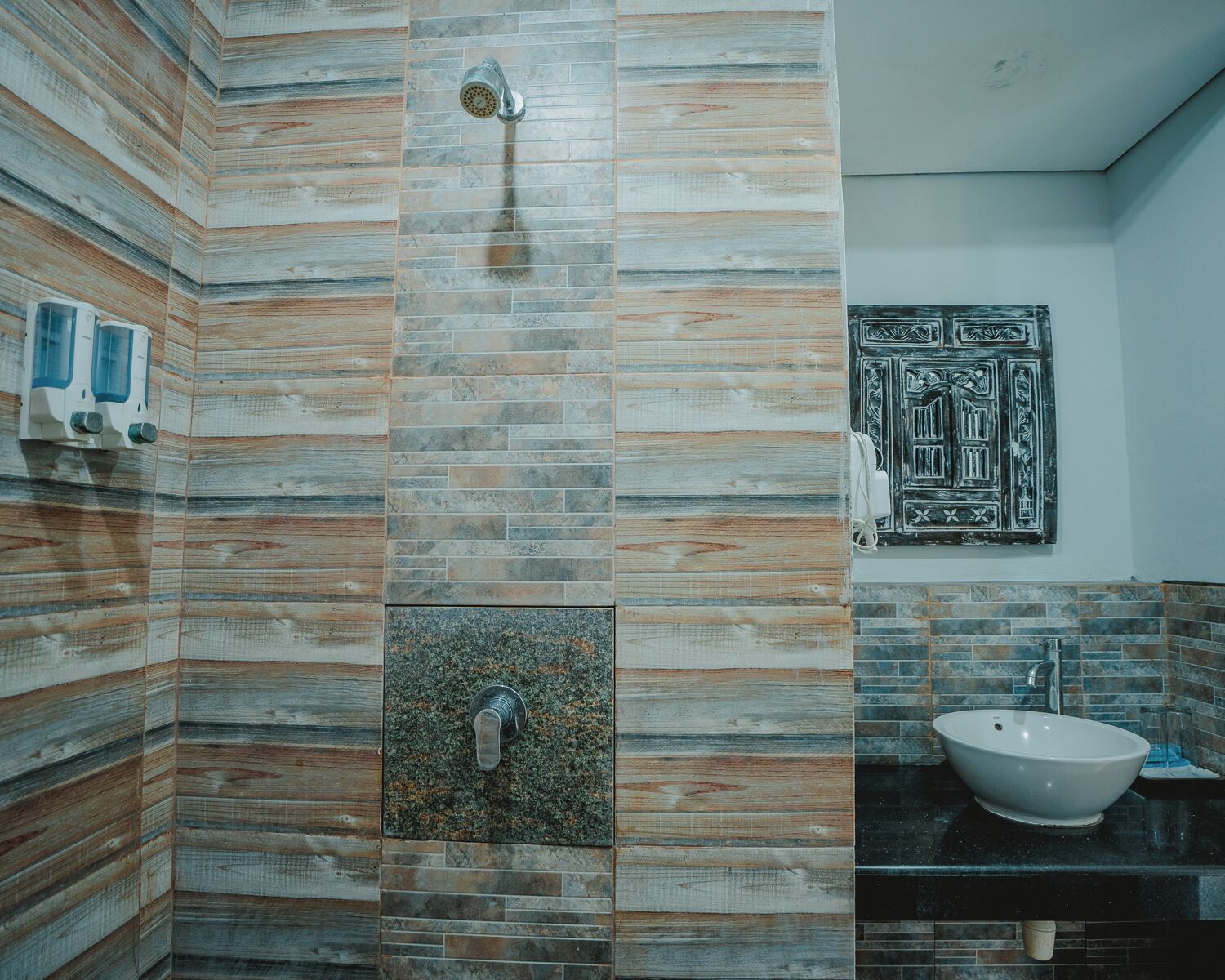 A bathroom with a shower, a sink, and a decorative door.