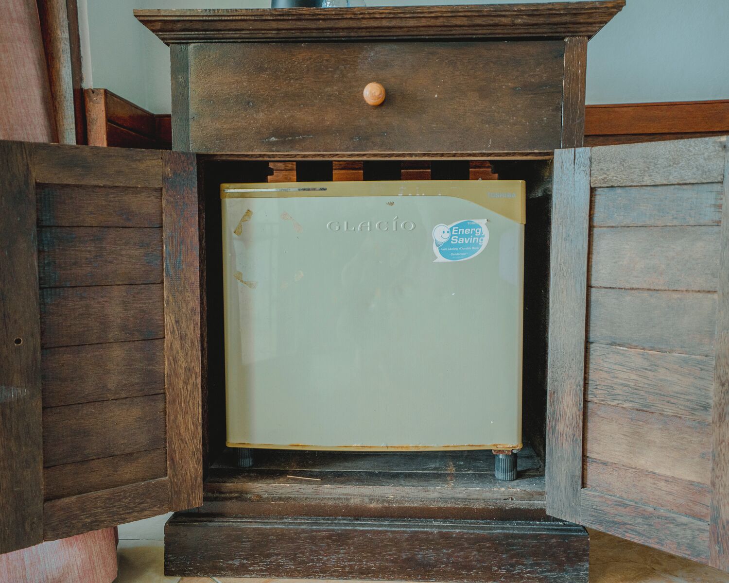 A vintage refrigerator with a sticker indicating energy saving.